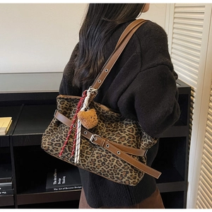 Detailed close-up of leopard print tote bag with brown leather strap and bear charm
