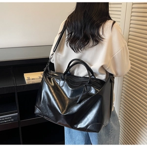 Détail du sac cabas noir en similicuir avec double poignée et bandoulière réglable