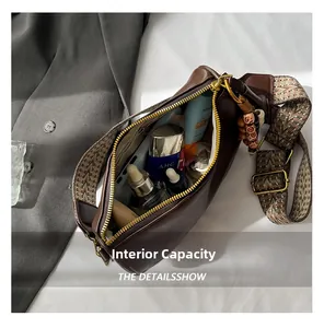 Spacious interior of dark brown Boston bag with wide strap and bead charm accessory