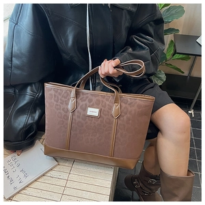 Détail d'un grand sac cabas marron avec imprimé léopard et finition en similicuir
