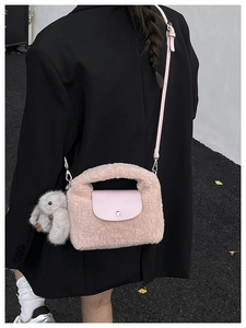 Detailed shot of pink faux shearling crossbody bag with leather flap and bunny charm