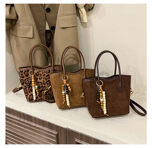 Détail de sacs à main avec pendentifs en perles de bois et bandoulières amovibles