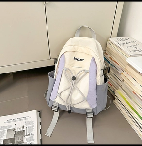 Detail van het grijze trekkoordsysteem en het zijvak op de beige-paarse rugzak