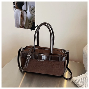 Detail of vintage brown bucket bag showing suede and smooth leather patchwork and buckle