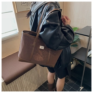 Vue détaillée du sac cabas léopard porté par un mannequin dans un cadre moderne