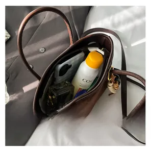 Vue détaillée du grand intérieur du sac cabas en daim marron avec objets du quotidien