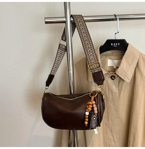 Detail of dark brown boston bag with ethnic style wide strap and decorative beads