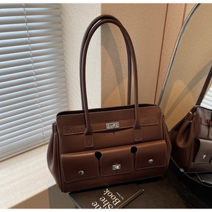 Detail of dark brown vintage faux leather tote bag showing side pockets and metallic lock