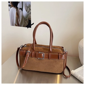 Detail of brown suede bucket bag with leather patchwork and vintage metal buckle