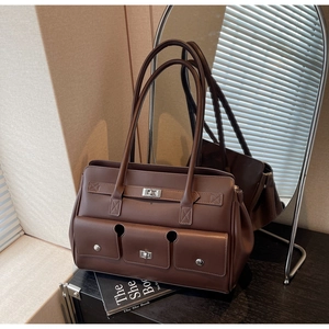Detail of vintage dark brown leather tote with front pockets and silver twist lock