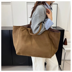 Macro detail of large brown suede tote bag showing premium leather texture and stitching