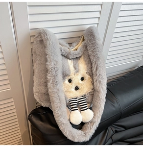Détail d'un sac cabas en peluche lapin gris avec de longues oreilles sur un canapé