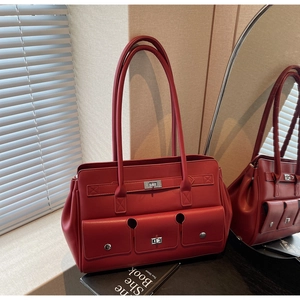 Detail of red leather tote bag showing three functional pockets and silver twist locks
