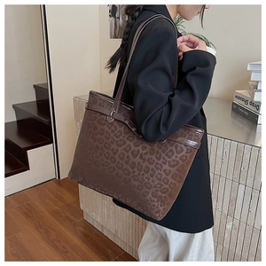 Détail du sac cabas léopard avec œillets métalliques et bandoulière sur le mannequin