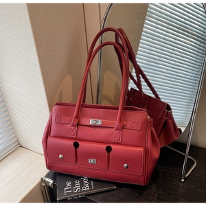 Detail of red vintage leather tote bag featuring functional pockets and silver twist lock