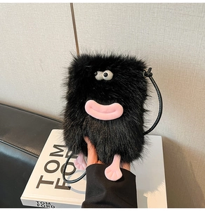 Detail showing plush black monster bag with pink monster lips and fun cartoon eyes