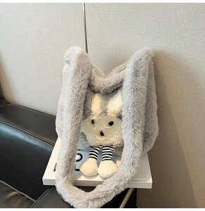 Gros plan sur le sac en peluche gris avec un visage de lapin 3D et de longues jambes rayées
