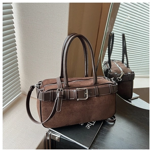 Detailed close-up of retro suede patchwork bucket bag with adjustable leather straps