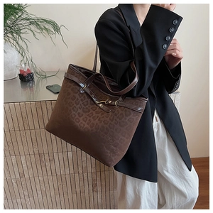 Détail du grand sac cabas en daim léopard avec bandoulière en cuir marron