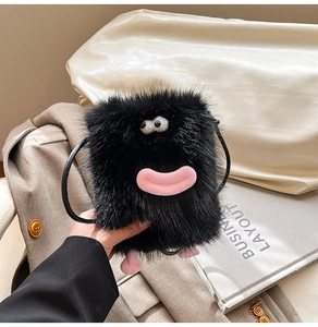 Detailed macro view of fuzzy black monster plush bag with large eyes and pink lips