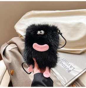 Detail view of the black plush monster bag featuring a fuzzy texture and pink cartoon lips