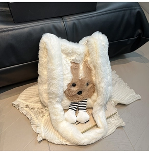 Détail du sac cabas en peluche blanche avec tête d'ours brun et nœud rayé décoratif