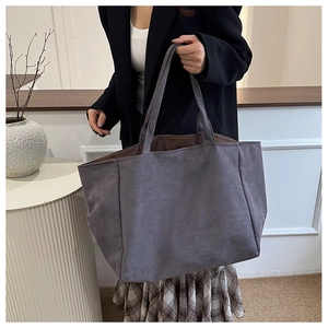 Close-up of deep grey-purple tote bag showing the soft brushed suede texture and strap