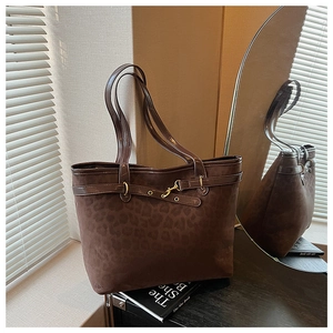 Détails de la texture léopard et boucle dorée sur ce sac cabas en daim marron