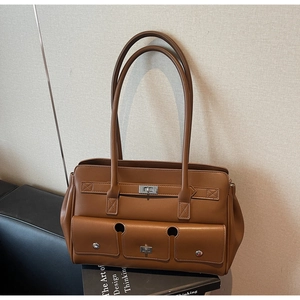 Detailed macro view of vintage brown leather tote bag with silver metal twist-lock pockets