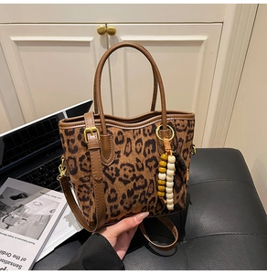 Détail du sac seau léopard avec anses en cuir et breloque décorative en perles de bois
