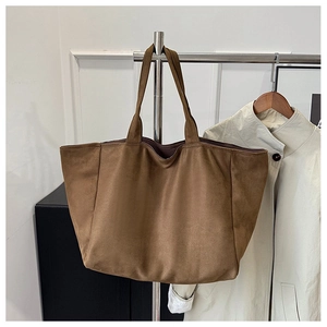 Macro shot of large brown suede tote bag showing soft texture and premium matte finish