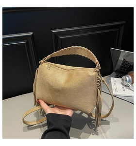 Detail of khaki frosted suede handbag with woven handle and side tassel accents