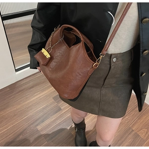 Detail of vintage brown PU leather bucket bag with matching mini coin purse and gold chain