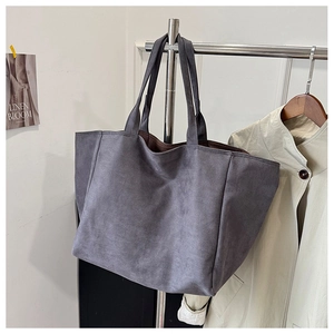 Detail of gray frosted tote bag showing spacious brown interior and minimalist design