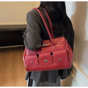 Detail view of vintage dark red leather tote bag with silver locks and multi-pocket design