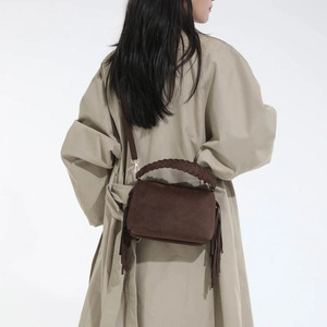 Detail of vintage dark brown frosted handbag featuring woven handle and long side tassels