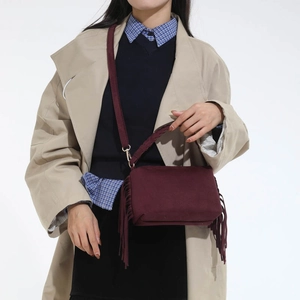 Burgundy matte leather crossbody bag featuring long fringes and adjustable strap