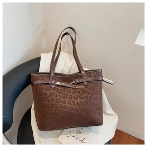 Détail du sac cabas à imprimé léopard avec garniture en cuir brun et boucle métallique dorée