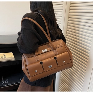 Rear view of model wearing a vintage brown tote bag with three functional front pockets