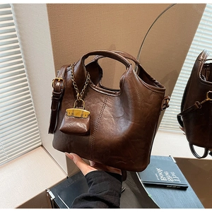 Vue détaillée du sac cabas en similicuir marron avec mini pendentif et coutures verticales