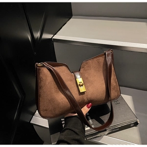 Détail du sac bandoulière en daim marron avec fermoir tournant doré et garniture