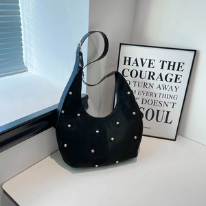 Dettaglio della borsa hobo in pelle scamosciata nera con borchie argentee e tracolla larga