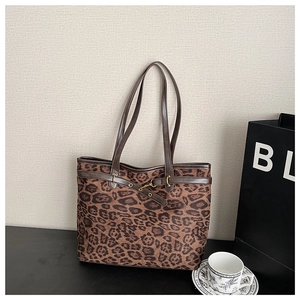 Détail du sac cabas léopard avec lanières en cuir marron et boucles dorées chic