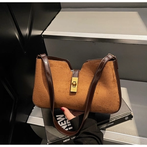 Détail du sac seau vintage en cuir mat avec boucle dorée et ouverture en forme de V