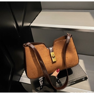 Détail de la texture en daim caramel et du fermoir doré sur ce sac hobo vintage chic