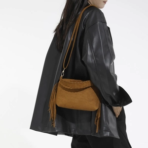 Brown suede crossbody bag with fringe tassel and bohemian stitch detail on model