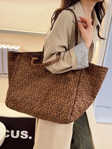 Large capacity leopard print tote bag for autumn fashion worn by a model in a minimal setting