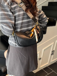 Fashionable black crescent shoulder bag with wide jacquard strap and colorful bead charm