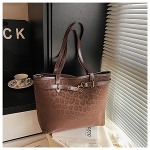 Gros plan détaillé du sac cabas léopard avec anses en cuir marron et boucles en métal
