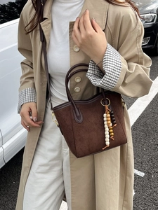 Sac seau en cuir mat marron foncé avec pompon en perles de bois et bandoulière amovible